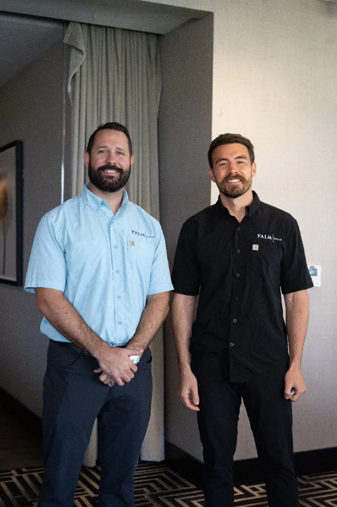 Mike and Wyatt from Palm Build leadership standing together in branded shirts